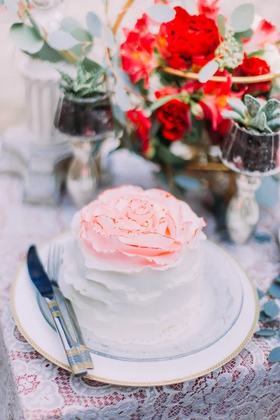 Кусочек свадебного торта, стилизованный под розу на столе с цветами крупным планом. День свадьбы — стоковое фото