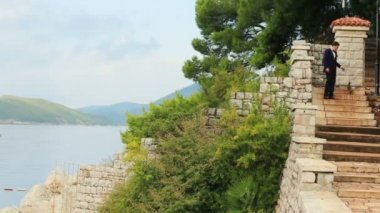 Merdivenlerden inip Karadağ, Budva sevimli terrier ile şık damat yürür