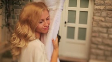 Harika sarışın gelin şefkatle onu dantel gelinlik tutar