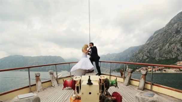 Menyasszony és a vőlegény ül a stern vintage yacht, vitorlázás a tengeren, Montenegro, Budva — Stock videók