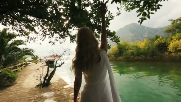 Joven pareja feliz boda caminando juntos en el antiguo muelle en Montenegro, Budva con el mar y las montañas en el fondo — Vídeo de stock