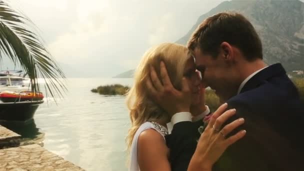 Jeune mariée heureuse et marié embrassant doucement avec la mer et les montagnes au Monténégro, Budva en arrière-plan gros plan — Video