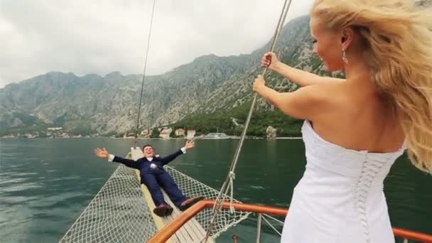 Щаслива весільна пара розважається на кормі корабля — стокове відео