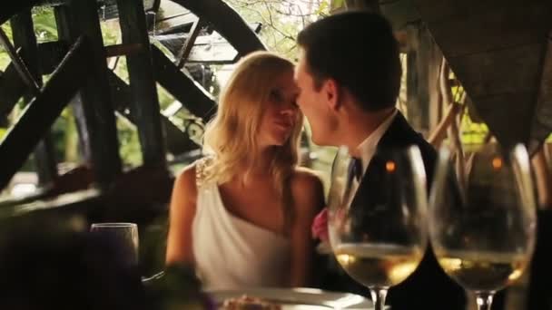 結婚式のカップル飲む発泡シャンパンと古いカフェでそっとキスをクローズ アップ — ストック動画
