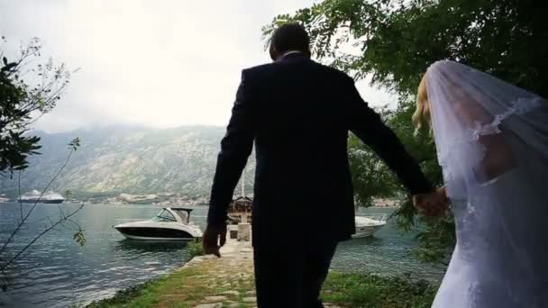 Couple de mariage marchant sur le bertn romantique au Monténégro, Budva — Video