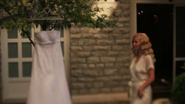 Vintage gelin elbisesini dokunmaktan ve mutlu bir şekilde gülerek beyaz elbise içinde güzel sarışın gelin