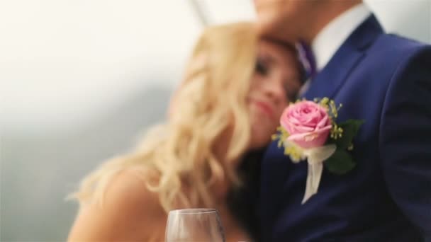Jeune mariée heureuse met doucement la tête sur la poitrine des mariés et souriant de près — Video