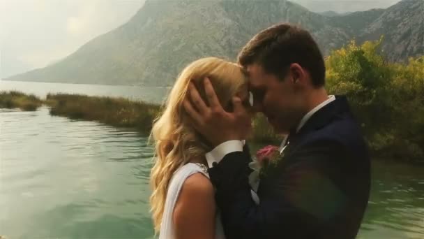 結婚式のカップルが海とモンテネグロの山と優しくキス、ブドヴァの背景にクローズ アップ — ストック動画