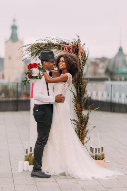 Beautiful young black wedding couple dreamily looks into the sky