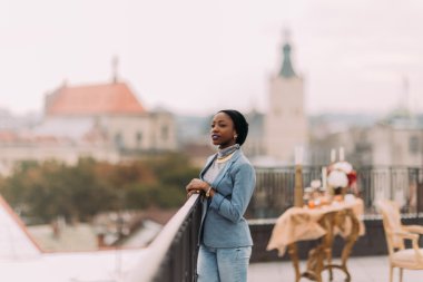 Güzel Afrikalı kız çatı da ayakta harika Lviv mimarisinin manzarasına sahiptir