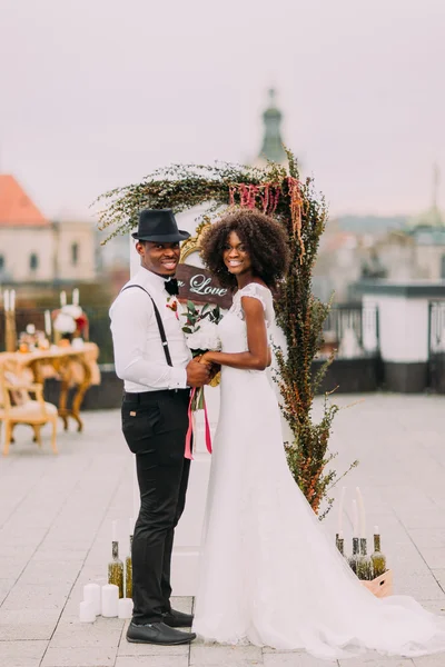 Casamento africano feliz casal sorrindo e de mãos dadas no telhado — Fotografia de Stock