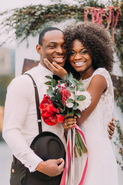 Sevimli Afrikalı gelin, düğün töreninde gülümseyen damadının karşısında el ele tutuşuyor