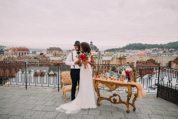 Mutlu Afrikalı gelin ve damat mutlu terasta sarılma