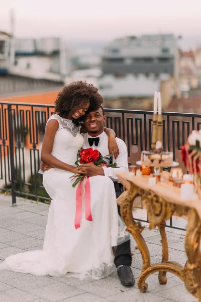 Büyüleyici siyah düğün çift şefkatle çatıda sarılma