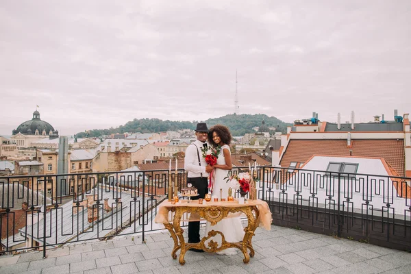 Glückliches afrikanisches Hochzeitspaar posiert auf der Terrasse für die Kamera — Stockfoto