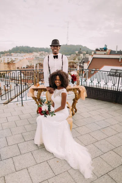 Maravilhoso casal recém-casado posando para câmera no terraço com bela paisagem Lviv no fundo — Fotografia de Stock