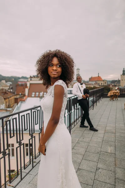 Schöne afrikanische Braut und stilvoller Bräutigam im Hintergrund posiert für die Kamera auf dem Dach — Stockfoto