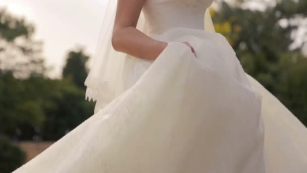 bella novia en danzas de vestido de encaje blanco en los campos