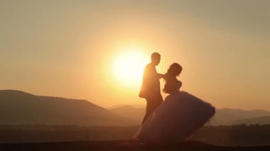 Düğün çift günbatımı üzerinde dans siluetleri