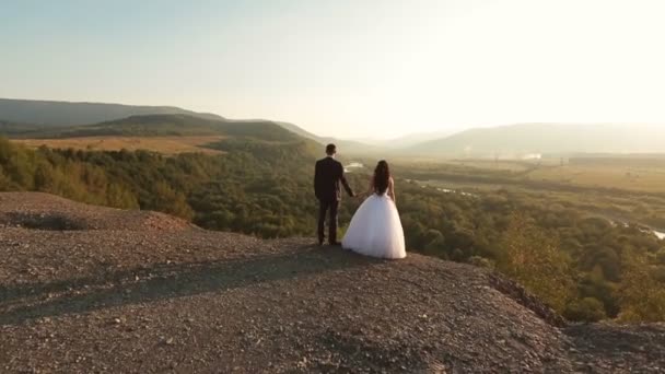 Hermosa pareja de boda tomados de la mano en la montaña de cerca — Vídeos de Stock