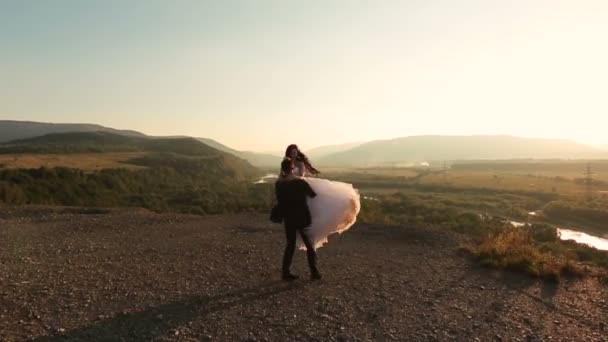 Hochzeitspaar küsst und tanzt auf dem Berg. Flitterwochen — Stockvideo