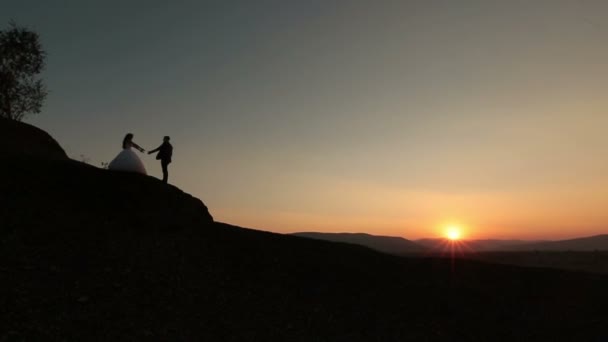 Bruiloft cuople zoenen op de zonsondergang in de bergen — Stockvideo