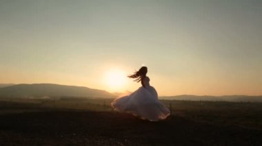 Gülen, atlama ve having fun on sunset dağlarda güzel gelin