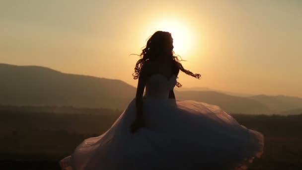 Silhouette de mariée rire et s'amuser sur le coucher du soleil dans les montagnes — Video