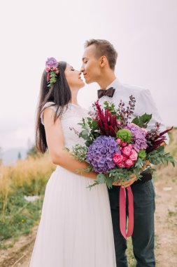 Buket elinde mutlu gelin ve damat öpücükle kapatalım