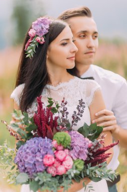 Mutlu gelin ve damat ile buket elinde. Alp Dağları balayı