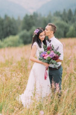 Düğün çifti alanında poz. Dağlar balayı