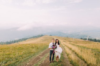 Puslu dağlar yolundaki poz Düğün çifti