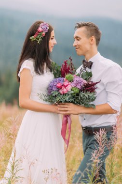 Mutlu evlilik çift birbirlerine bakıyorlar. Arka plan üzerinde Alp Dağları