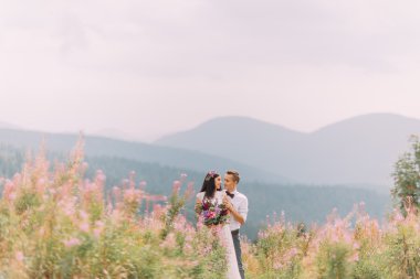 Genç mutlu evlilik çift Alpleri'nde çayır üzerinde. Balayı