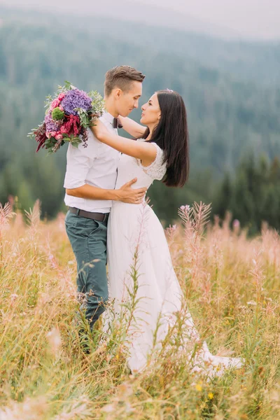 Счастливая супружеская пара мягко обнимается. Альпийские горы на заднем плане — стоковое фото