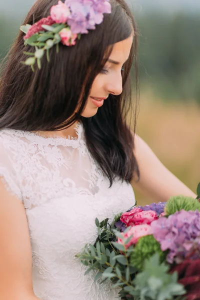 Härlig brunett brud med bukett i händerna på nära håll — Stockfoto