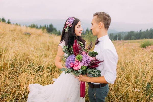 Sposa e sposo si guardano amorevolmente sul campo — Foto Stock