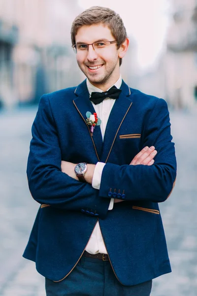 Joyeux beau marié en costume bleu regarde dans la caméra et souriant — Photo