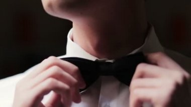 Şık damat ayarlar onun papyon yakın.