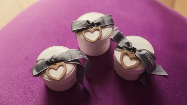 Cajas con anillos de boda sobre fondo púrpura — Vídeos de Stock