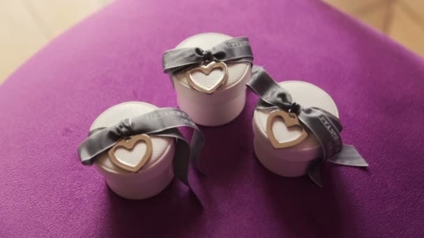 Cajas con anillos de boda sobre fondo púrpura — Vídeo de stock