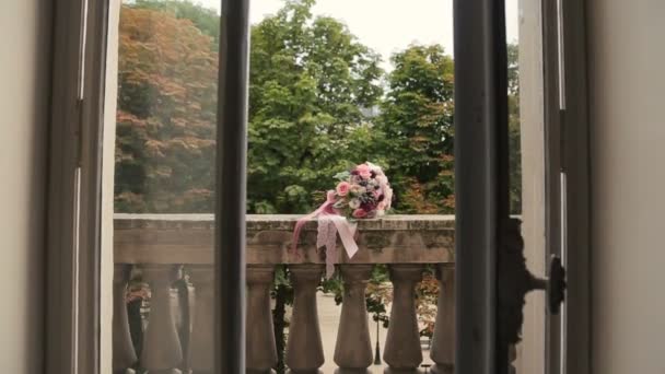 Schöner Hochzeitsstrauß mit rosa Schleifen auf dem Balkon liegend — Stockvideo