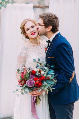 Mutlu beyaz arka plan ile muhteşem sarışın gelin damat kisses