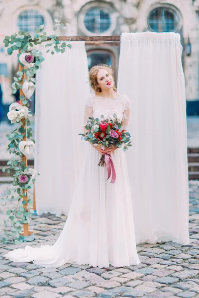 Noiva loira encantadora com bouquet de casamento de luxo em vestido de casamento vintage branco suavemente sorrindo em seu dia do casamento — Fotografia de Stock