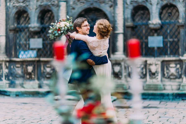 Casal feliz dançando no centro da cidade de Lviv no dia do casamento. Antiga arquitetura Lviv em segundo plano — Fotografia de Stock