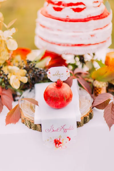 Granada roja grande de cerca con pastel de boda en el fondo —  Fotos de Stock