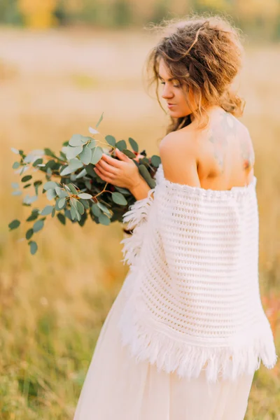 Linda noiva tatuagem em vestido branco com buquê no campo — Fotografia de Stock