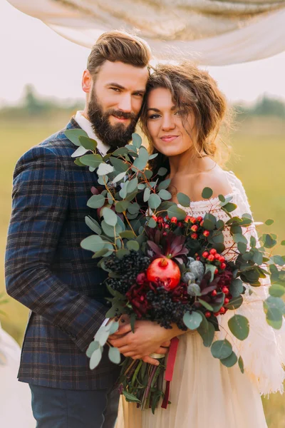 Büyüleyici yeni evliler el ve düğün töreni sırasında gülümseyen tutun