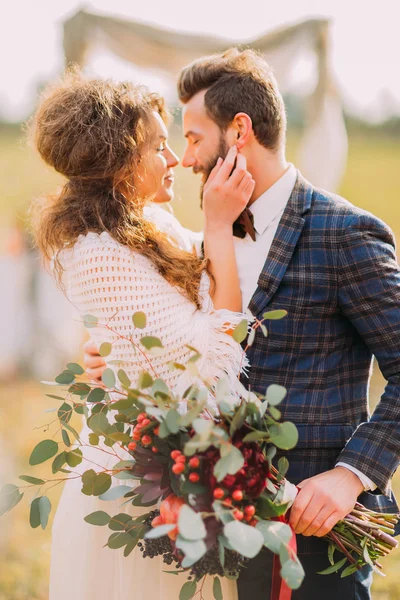 Noiva encantadora segura noivos rosto em mãos de perto — Fotografia de Stock