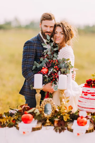 Feliz pareja de boda sonriendo en la mesa de vacaciones. Fondo de campo — Foto de Stock